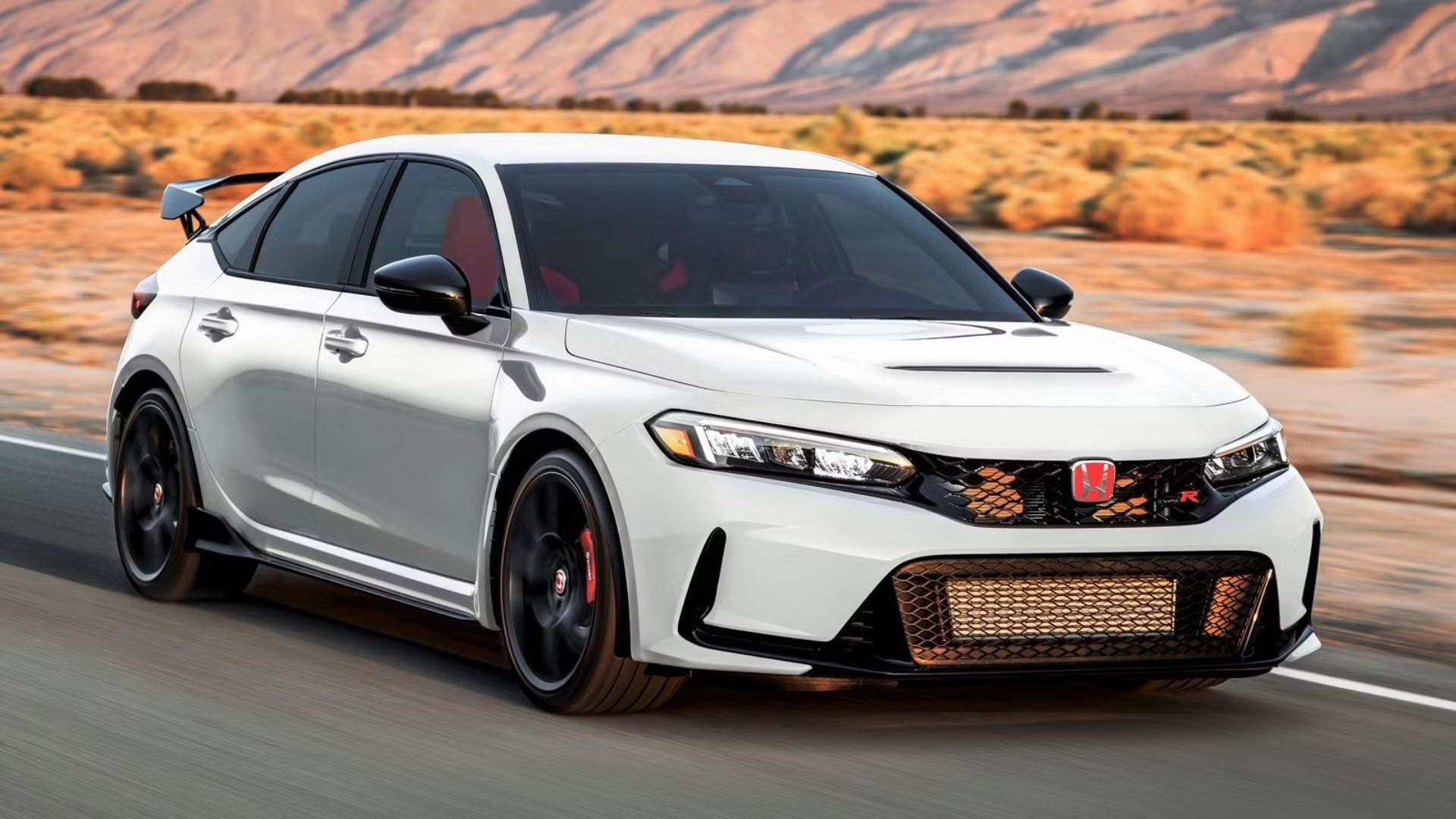 White Honda Civic Type R front quarter view driving on desert road