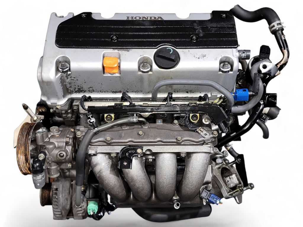 Honda car engine with visible exhaust manifold and metal components on white background