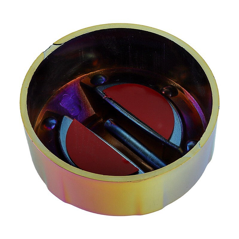 Close-up of a gold tone sharpener with two red circular blades inside a round metal case